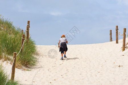 孤独的男孩穿过沙丘图片