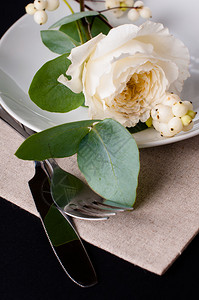 黑色背景的花装饰白玫瑰叶子和浆果的图片