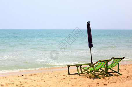沙滩上带伞的两把椅子图片