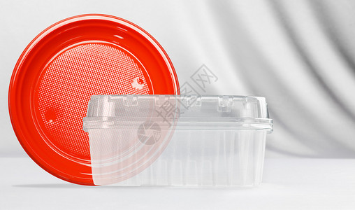 白色背景的塑料透明集装箱和红色塑料板取走概念图片