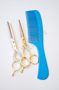 白色背景上的蓝色梳子和剪刀图片