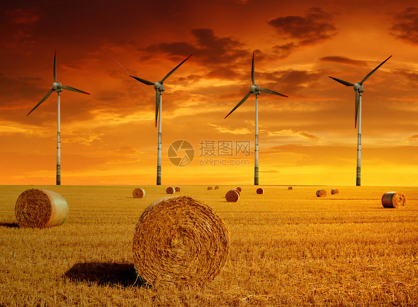 夕阳下的风力涡轮机稻草捆图片