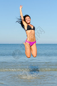 在海滩上跳水的快乐女人图片