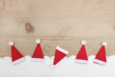红色圣诞帽木制背景上的钩针雪图片