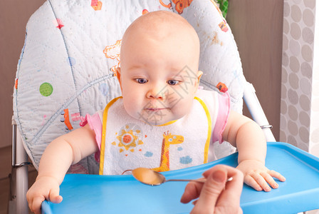 小婴儿在厨房用勺子喂食图片