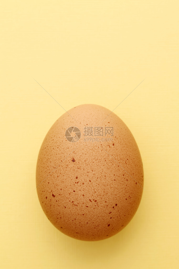 黄色背景中的棕色鸡蛋图片