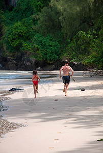 父亲带着女儿在沙滩上奔跑图片