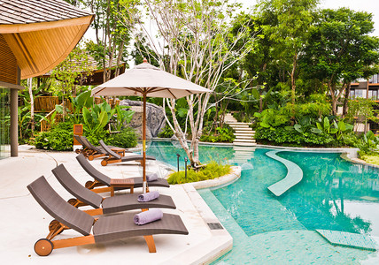 泰国的沙滩椅和伞边游泳池图片