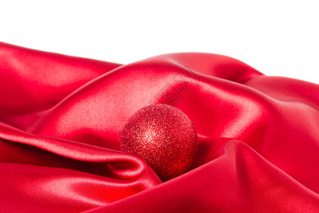 红色丝绸布上的红色圣诞球背景图片