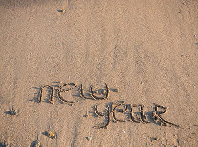 新年2014年即将到来的概念沙滩上的题字2013年和年图片
