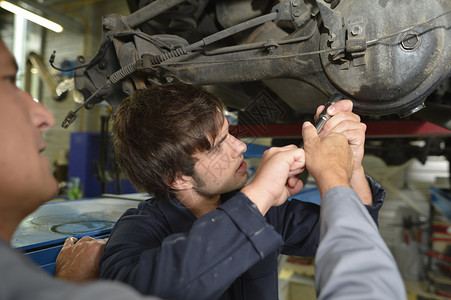 机械师和学生在汽车修理厂图片