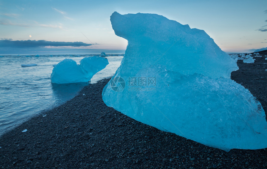 冰山漂浮在Jokulsarlon冰川环礁湖海滩附近日落图片