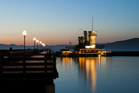 灯塔餐馆在黎明时分的一条人行道旁水中图片