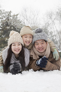 一家人躺在雪地里拍肖像背景图片