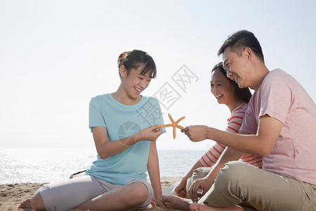 一家人坐在海边的海滩图片