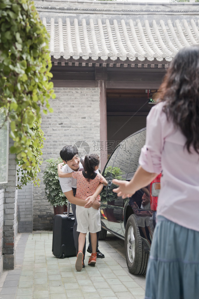 商人在从商务旅行回来后抱着图片