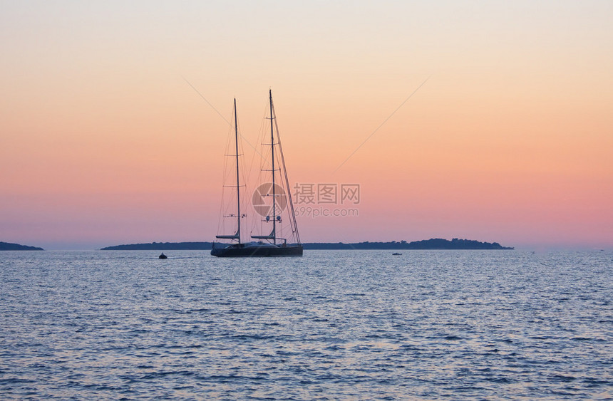帆瘪的帆船日落后的大海图片