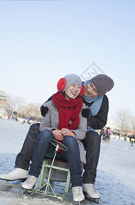 年轻夫妇滑冰坐在冰雪橇上图片