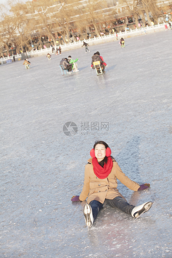 滑冰时跌倒的年轻女子图片