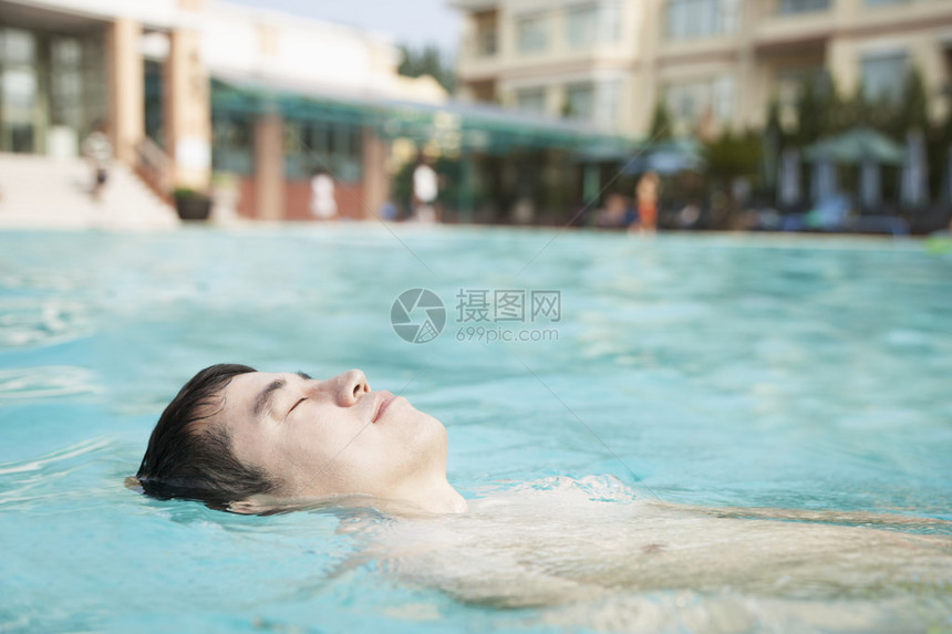 放松的人漂在泳池图片