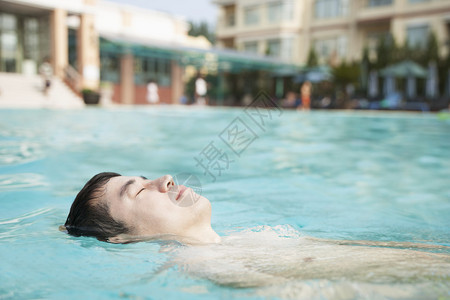 放松的人漂在泳池图片