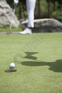 在高尔夫球场上打球的年轻女子低层图片