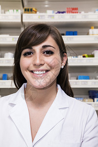 微笑的年轻药剂师的肖像看着一个药背景图片
