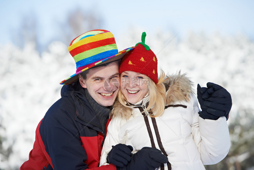 在冬雪户外的冬季雪中戴着圣诞节帽的年轻图片