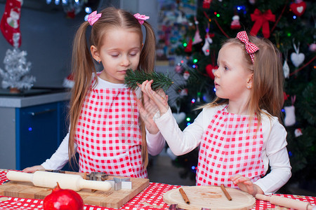 两个可爱的小女孩为圣诞节准备姜饼图片
