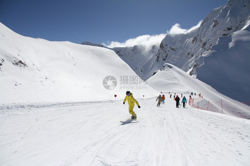 滑雪者和单板滑雪者在滑雪胜地的斜坡上下来俄罗斯索契卡拉斯图片
