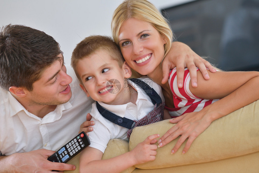 快乐的年轻家庭与孩子在明亮现代起居室玩得开心图片