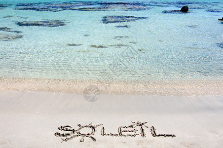 SOLELIL字是写在一个美丽的沙滩上的沙子上图片