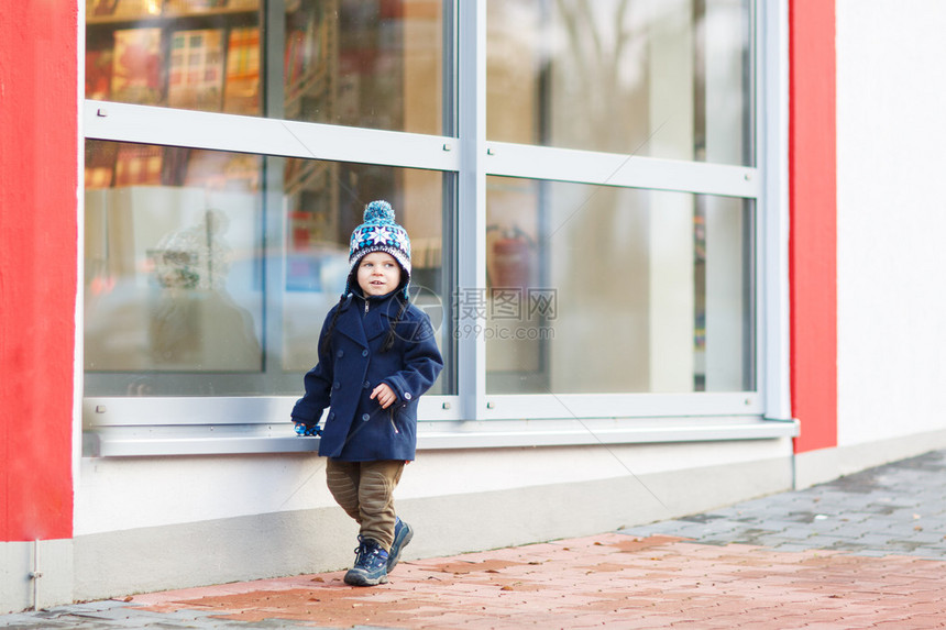 小男孩坐在城市的大窗户前户外冬天图片