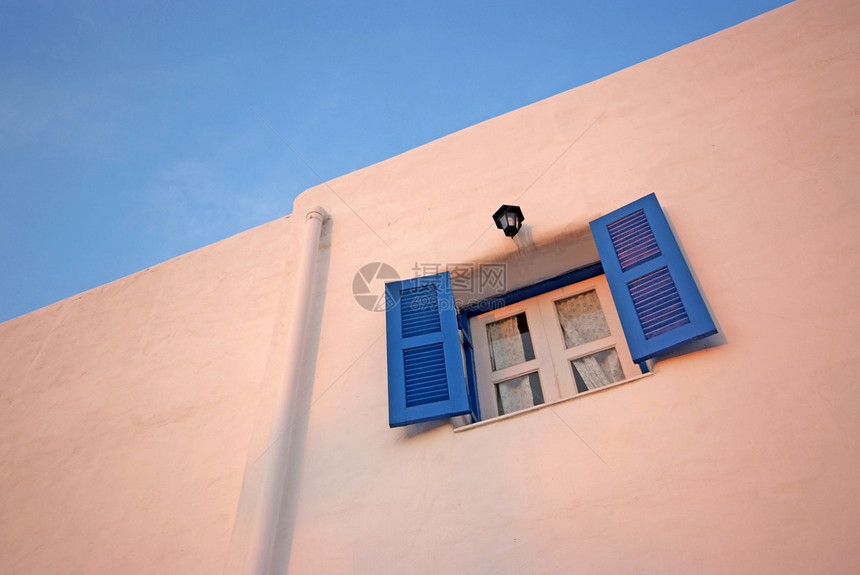 白色墙壁和蓝天上的复古蓝色窗户图片