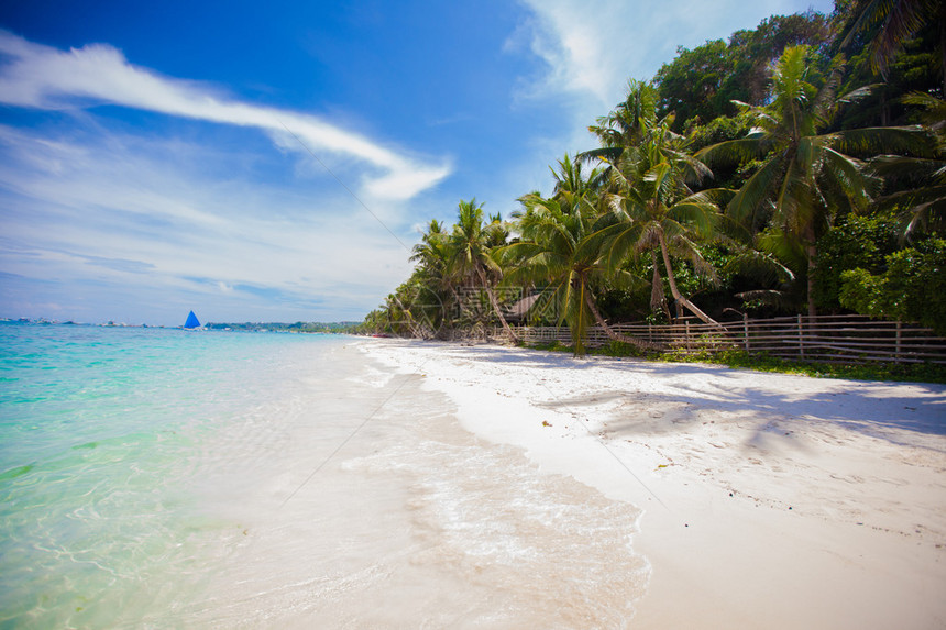 理想的热带海滩碧绿的海水和白色的沙滩图片