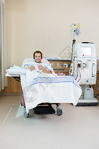 在病房接受肾透析治疗时微笑的男患者图片