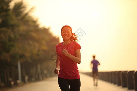 早晨日出后在海边奔跑的美丽女士图片