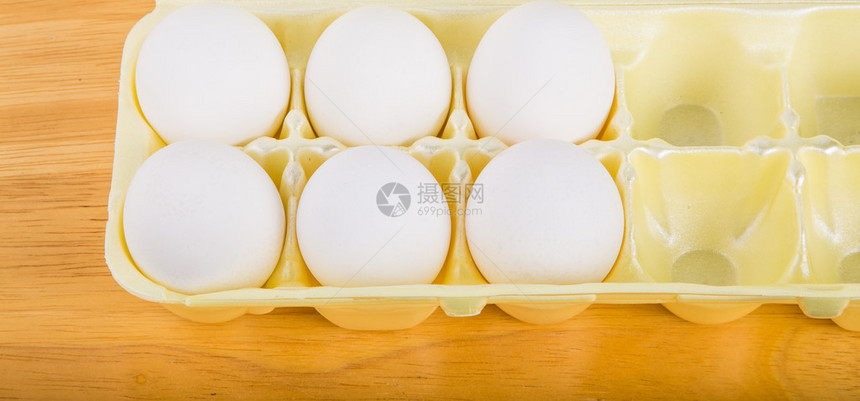 黄色泡沫鸡蛋盒中的半打鸡蛋图片