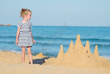 沙滩上有沙堡的小女孩图片