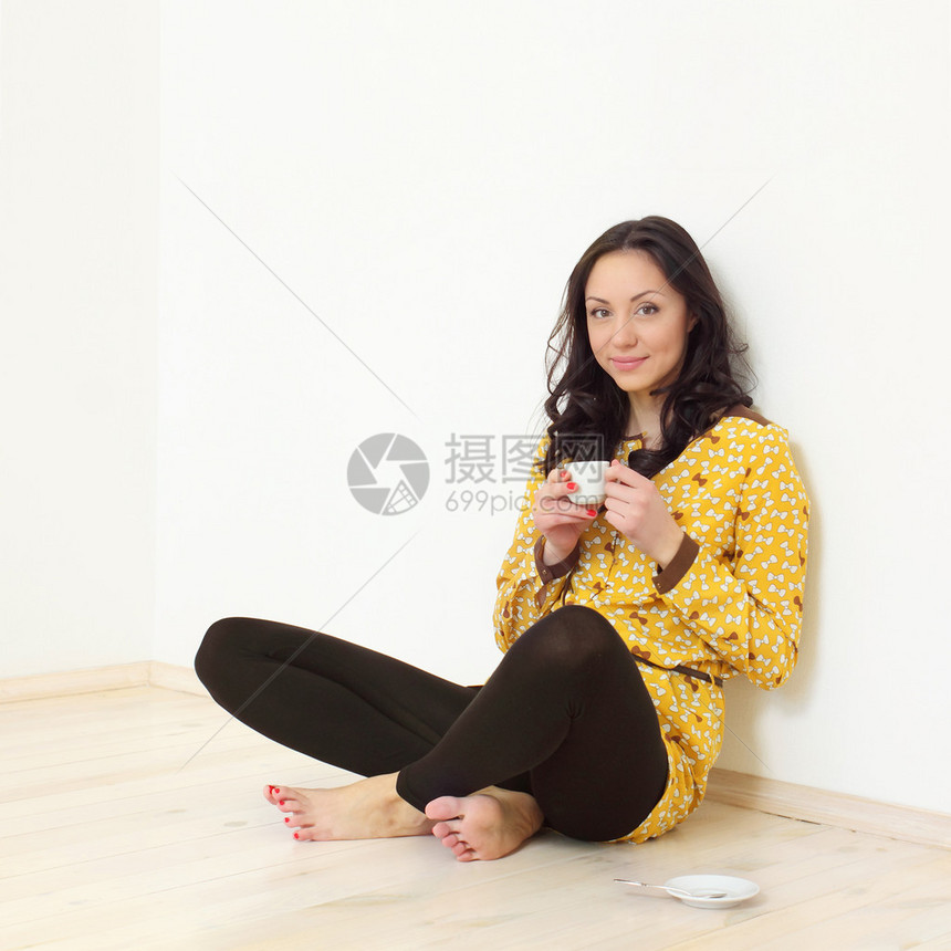 在地板上喝咖啡的长发女孩图片
