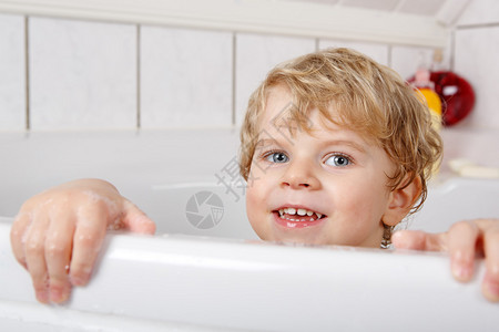 可爱的小孩两年的男孩通过洗澡在浴图片
