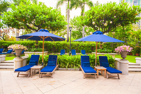 豪华酒店游泳池附近带遮阳伞的沙滩椅图片