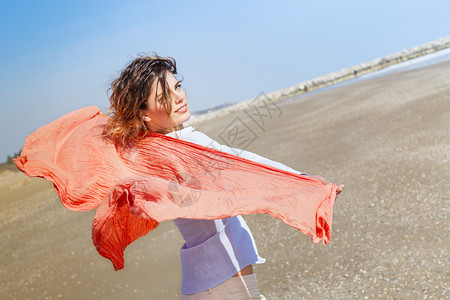 沙滩上戴着红围巾的美少女图片