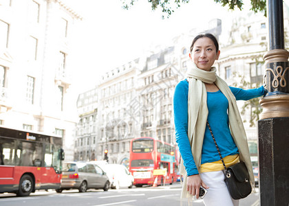有吸引力的日本旅游女在目的地城市伦敦的一条经典建筑街上享受观光图片
