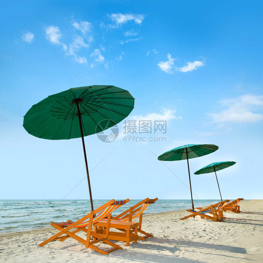 热带沙滩上的沙滩椅和遮阳伞图片