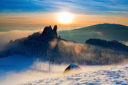 夕阳下冬日山上的小屋色彩斑斓的背景图片