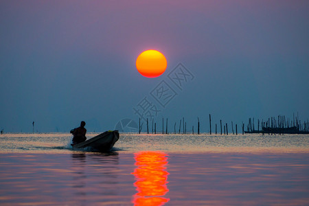 剪影渔夫和日落在湖上图片