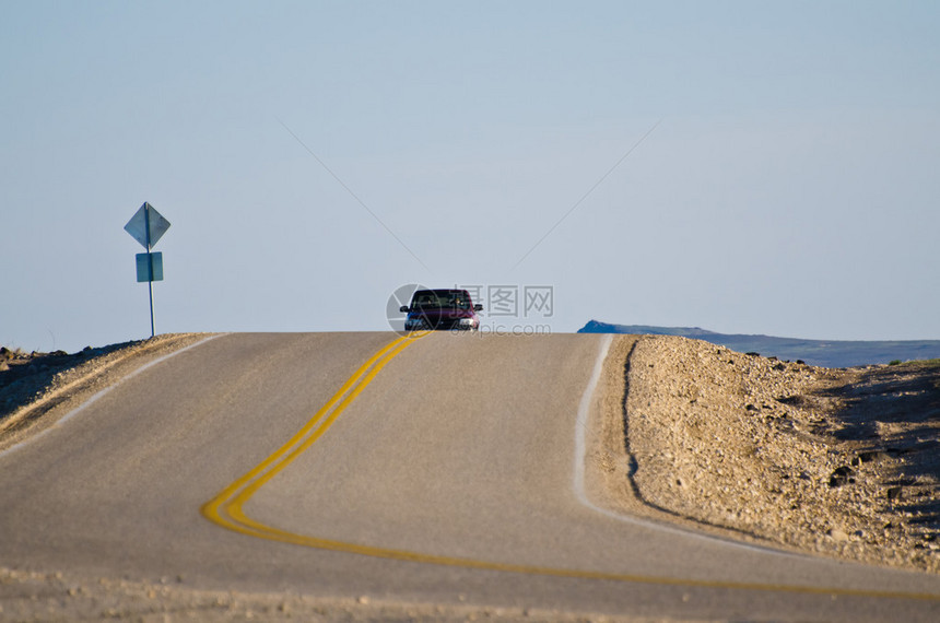 接近沙漠公路的汽车图片