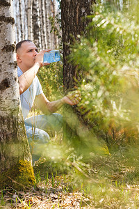 人在春天森林里喝桦树汁图片
