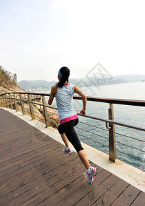 赛跑运动员在海边奔跑女健身日出慢跑锻图片